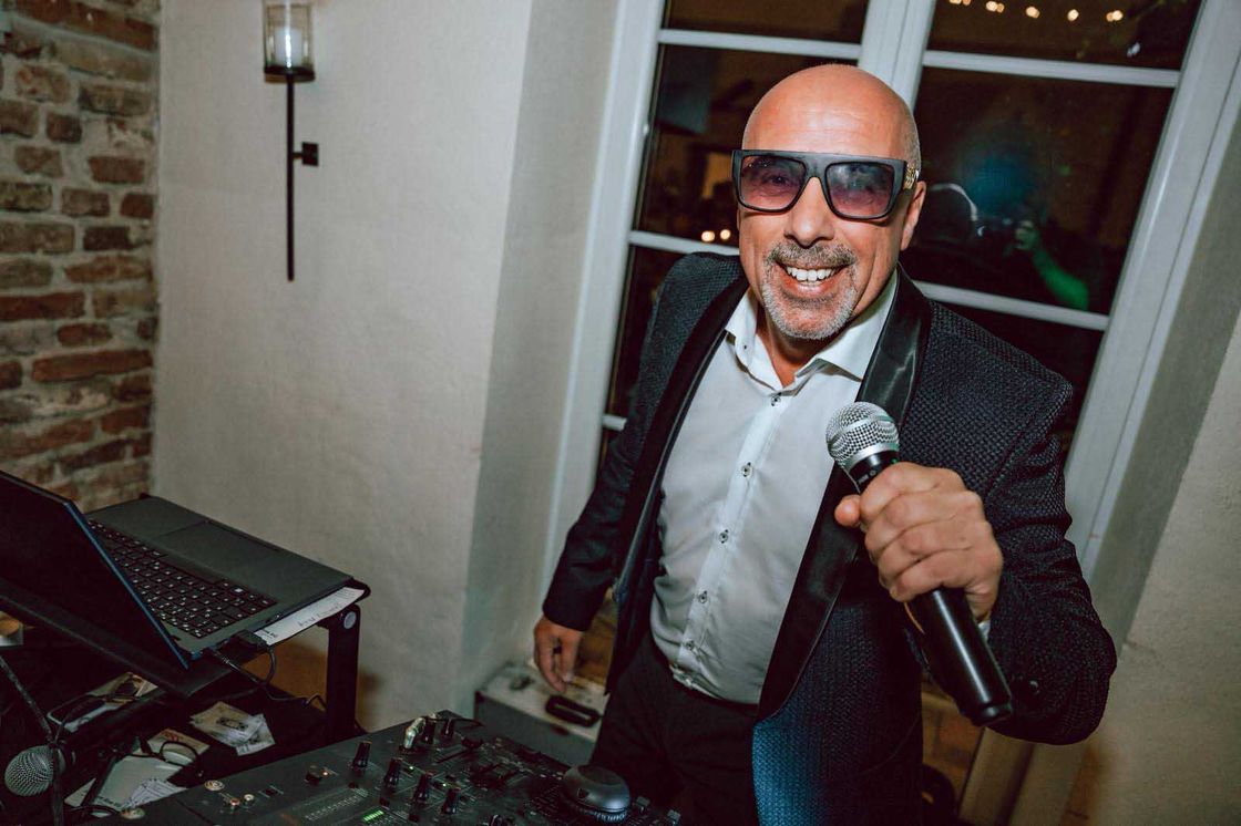 DJ Voltino mit Mikrofon sorgt für Partystimmung auf einer Feier in München
